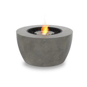A modern outdoor fire pit with a stainless steel burner, black fire stones, and a round, natural concrete base. The EcoSmart Fire Pod 40 is designed for seamless integration into fire pits for outside or patio lounge areas.