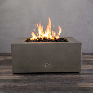 Starfire Designs Gravity 36-inch square concrete gas fire pit in brown with bright flames rising from black lava rocks. Modern outdoor fire pit made from durable concrete for residential and commercial use. Perfect for patios and backyards, this luxury fire pit adds warmth and ambiance. High-quality fire pit with stainless steel burner and propane/natural gas compatibility