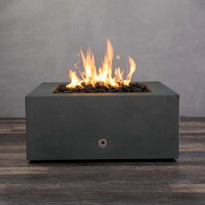 Front view of the Starfire Designs Gravity 36-inch Square Concrete Gas Fire Pit in Graphite with bright flames burning over black lava rocks. This luxury outdoor fire pit features a sleek, modern concrete design in dark graphite, perfect for enhancing any outdoor patio or garden space. It provides ample heat while adding style to any outdoor setup.
