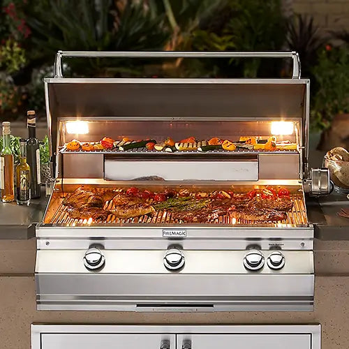 a closeup of a fire magic grill full of wonderful food being cooked with a bright backlight internally to see the grilling progression