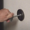 A closeup of a steel key valve is being turned to the on position by someones hand
