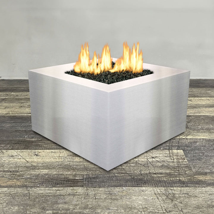 Front view of 36" Square Gravity Stainless Steel Fire Pit by Starfire Designs - Brown with flames on, featuring sleek modern  design and durable construction, perfect for outdoor patio spaces. Natural gas or propane compatible, enhancing warmth and ambiance. Lava rocks included for added aesthetic.