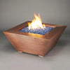 Starfire Designs 40-inch Copper Canyon gas fire pit with vibrant blue fire glass, showcasing a hammered copper finish, perfect for outdoor modern fire pits