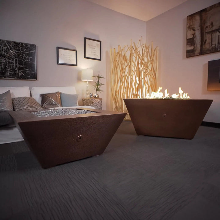 40-inch Copper Canyon gas fire pit by Starfire Designs, displayed in a cozy indoor setting, with a hammered copper finish and sleek design, ideal for modern outdoor fire pits