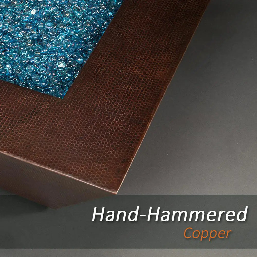 Close-up of the hand-hammered copper edge and blue fire glass of the Plaza Moreno 40" square fire pit, showcasing the detailed craftsmanship and premium materials used in this modern outdoor fire pit by Starfire Designs