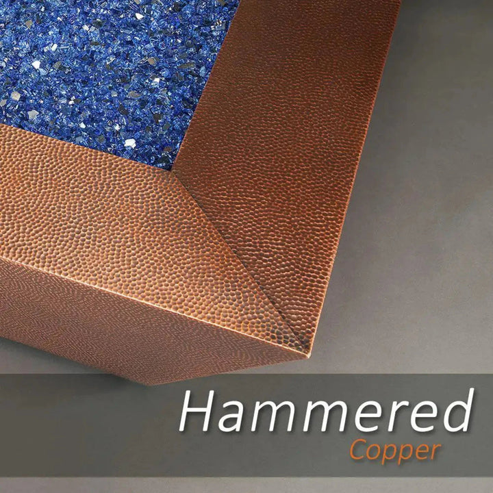Detail view of the 48-inch Copper Canyon gas fire pit by Starfire Designs, showcasing the hammered copper finish and vibrant blue fire glass, perfect for upscale outdoor fire pits