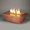 Detail view of the 48" x 32" Copper Canyon gas fire pit by Starfire Designs, showcasing the hammered copper finish and vibrant golden fire glass, ideal for upscale outdoor settings
