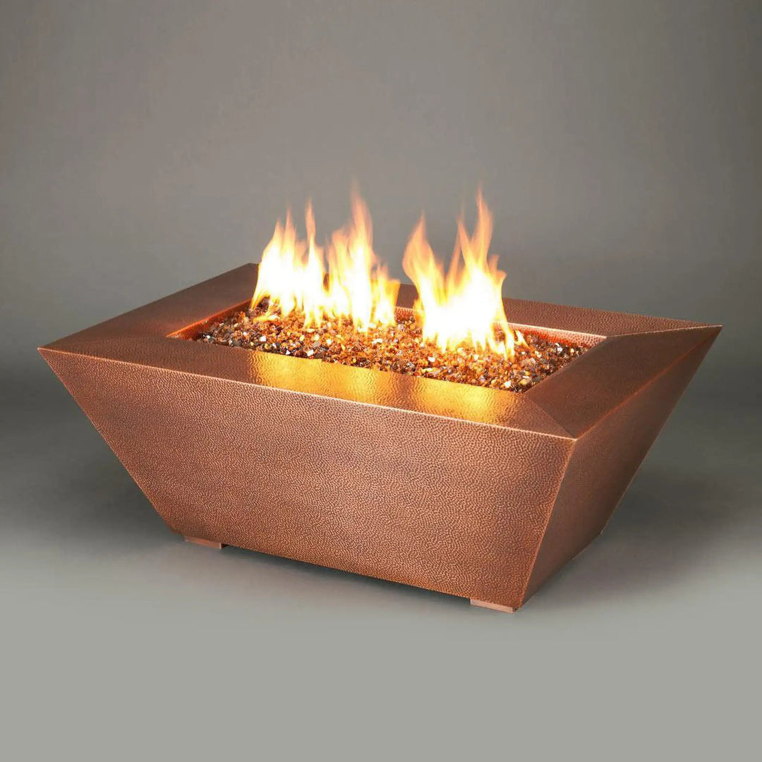 Detail view of the 48" x 32" Copper Canyon gas fire pit by Starfire Designs, showcasing the hammered copper finish and vibrant golden fire glass, ideal for upscale outdoor settings