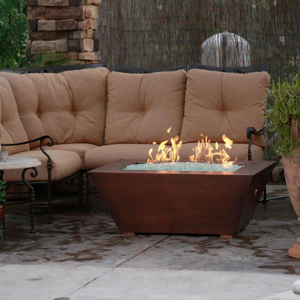 48" x 32" Copper Canyon gas fire pit by Starfire Designs, placed in a cozy outdoor seating area, with a hammered copper finish and elegant design, ideal for modern outdoor fire pits