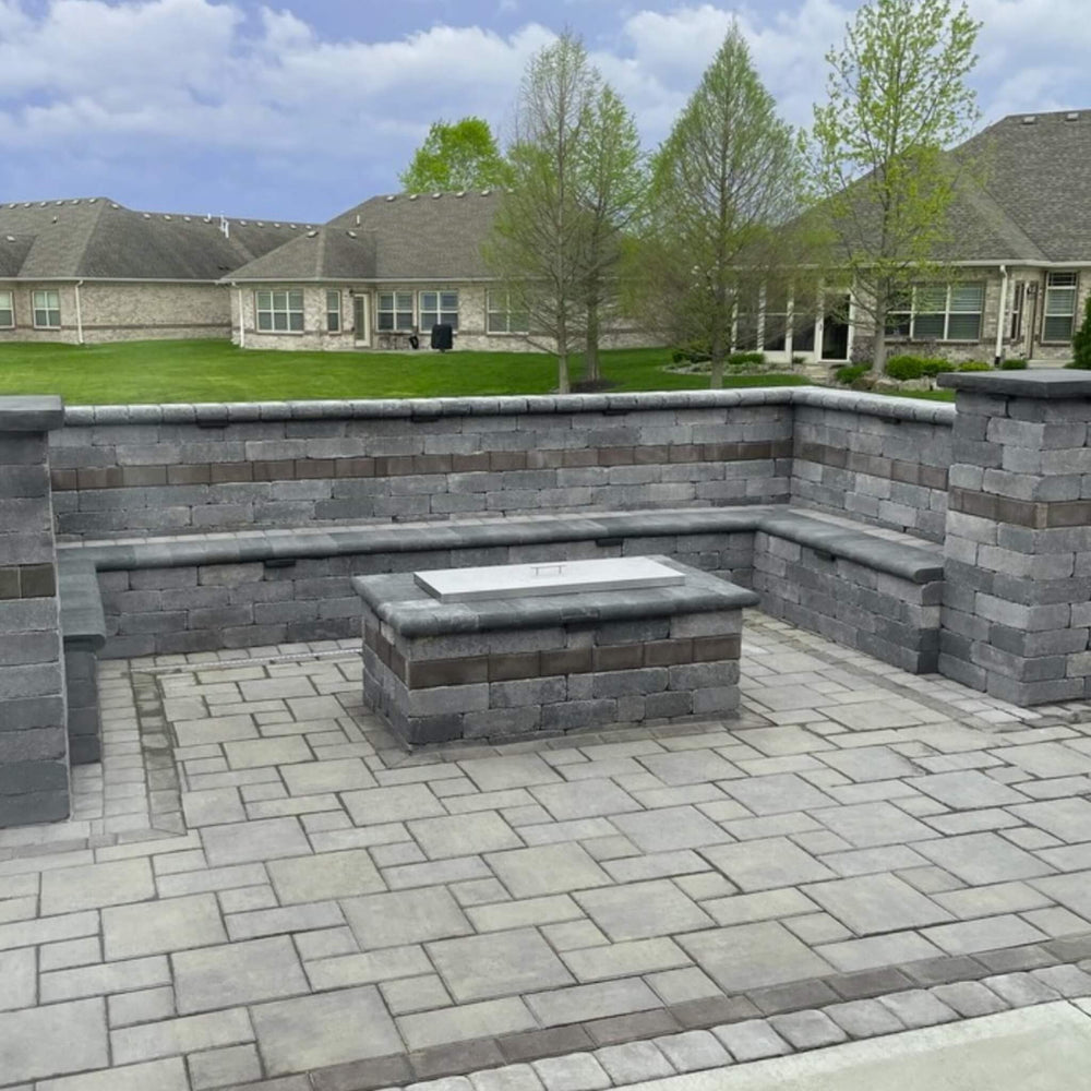 Modern outdoor patio with built-in stone seating and a central fire feature topped with an American Fire Products rectangular stainless steel burner cover—blending durability and sleek design for stylish backyard living.
