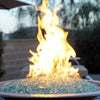 Close-up of vibrant flames rising from a copper fire bowl filled with American Fire Products 1/4" Non-Reflective Classic Fire Glass in light aqua, showcasing a clean, contemporary fire feature perfect for upscale outdoor spaces.