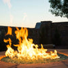 Vibrant backyard fire feature glowing with American Fire Products 1/4" Non-Reflective Classic Fire Glass, set into a stone fire pit and dancing with tall flames at sunset—ideal for creating a cozy and elegant outdoor atmosphere.