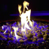 Close-up nighttime view of American Fire Products Small Gray Lava Stones glowing under mesmerizing blue and yellow flames, creating a dramatic and cozy ambiance in a fire pit enhanced with black fire glass.
