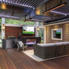 Elegant outdoor living area featuring Bromic Tungsten Electric Smart-Heat heaters on a modern covered patio with wicker furniture, a built-in TV, and a sleek gas fireplace.