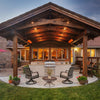 Backyard entertaining space with a rustic wood pergola and Bromic Tungsten Electric Smart-Heat heaters, keeping the outdoor kitchen and seating area comfortably warm.