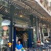 Restaurant patio entrance with Bromic Tungsten Electric Smart-Heat heaters wall-mounted above a striped canopy, keeping café guests comfortable while dining outdoors.