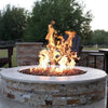 Rustic stone fire pit with a wide ledge and radiant copper fire glass, delivering high flames through an HPC Penta burner—ideal for luxurious outdoor ambiance.