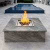 Poolside fire pit with a Square Drop-In Penta Burner installed in a luxurious granite-topped enclosure, producing elegant flames for elevated outdoor entertaining.