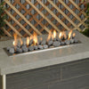 Outdoor fire feature with American Fire Products gray lava stones, neatly arranged over a linear burner, creating a modern flame display perfect for patios or backyard gatherings.