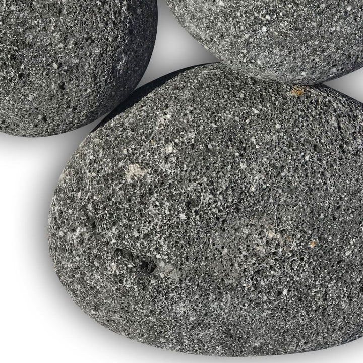 Close-up of extra-large black lava stones featuring a naturally rough, porous texture—ideal for bold, modern fire pit designs and superior heat performance.