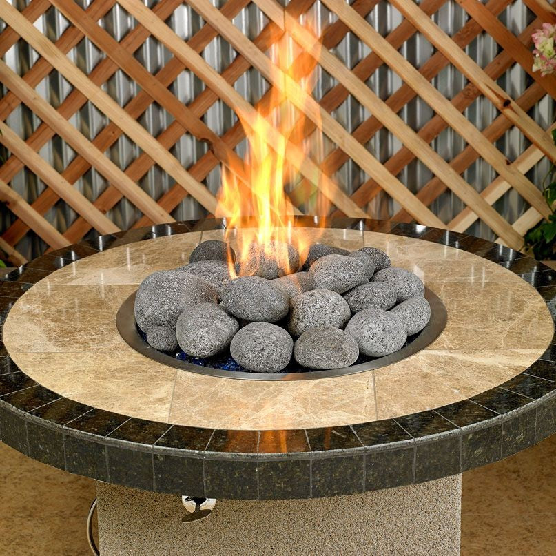 Round fire pit table with polished stone top featuring extra-large gray lava stones from Starfire Direct, producing vibrant flames for a modern, natural centerpiece in outdoor settings.