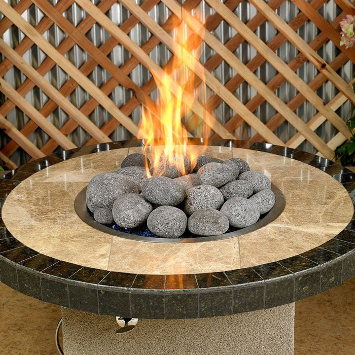 Round fire pit table with polished stone top featuring extra-large gray lava stones from Starfire Direct, producing vibrant flames for a modern, natural centerpiece in outdoor settings.
