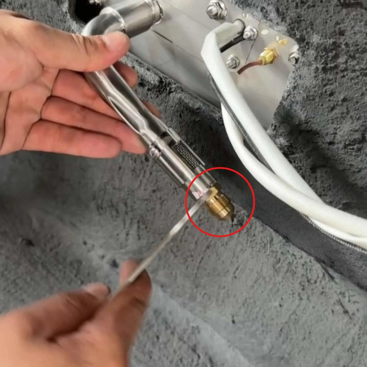 Technician installing the Starfire Designs Béton Fire Pit Replacement Orifice on a stainless steel gas line, demonstrating how the brass fitting connects to the burner assembly.