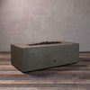 A side view of the Starfire Designs Gravity 48" x 32" Rectangle Rustic Gravity Concrete (GFRC) Fire Pit - Propane Gas Hardline - Brown with flames on, featuring sleek modern concrete bowl design and durable construction, perfect for outdoor patio spaces. Natural gas or propane compatible, enhancing warmth and ambiance. Lava rocks included for added aesthetic.
