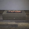 Front view of Starfire Designs Gravity 72" x 38" Rectangle Rustic Gravity Concrete (GFRC) Fire Pit - Propane Gas Hardline - Brown with flames on, featuring sleek modern concrete bowl design and durable construction, perfect for outdoor patio spaces. Natural gas or propane compatible, enhancing warmth and ambiance. Lava rocks included for added aesthetic.
