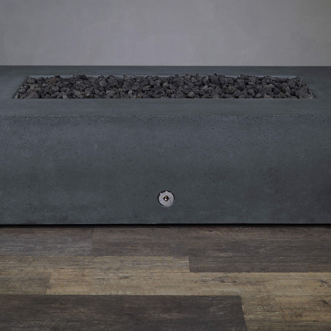 A side view of the Starfire Designs Gravity 72" x 38" Rectangle Rustic Gravity Concrete (GFRC) Fire Pit - Propane Gas Hardline - Graphite with flames on, featuring sleek modern concrete bowl design and durable construction, perfect for outdoor patio spaces. Natural gas or propane compatible, enhancing warmth and ambiance. Lava rocks included for added aesthetic.