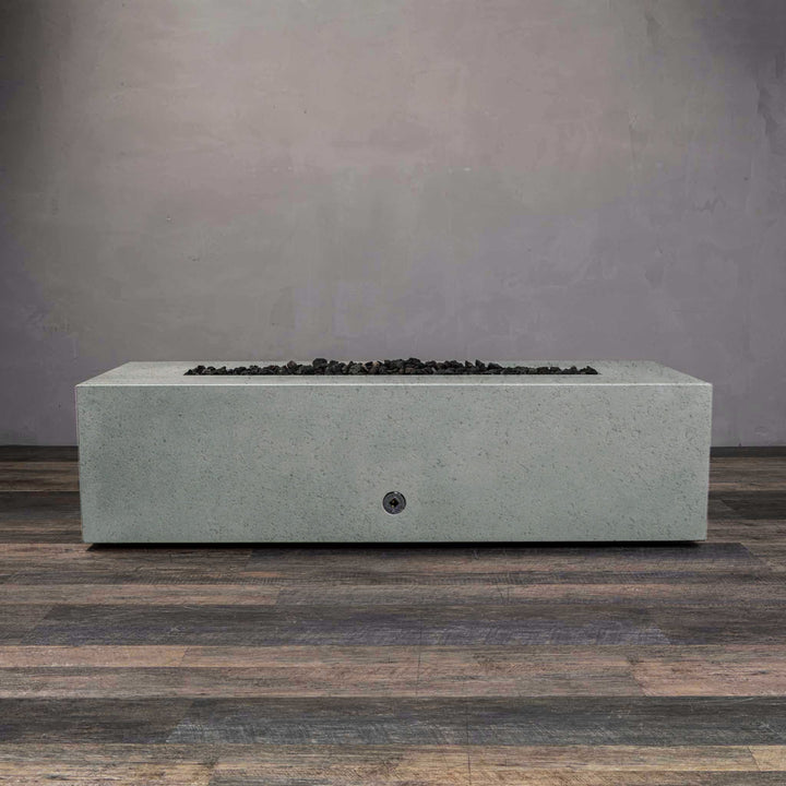 A side view of the Starfire Designs Gravity 60" x 32" Rectangle Rustic Gravity Concrete (GFRC) Fire Pit - Propane Gas Hardline - Natural Gray with flames on, featuring sleek modern concrete bowl design and durable construction, perfect for outdoor patio spaces. Natural gas or propane compatible, enhancing warmth and ambiance. Lava rocks included for added aesthetic.
