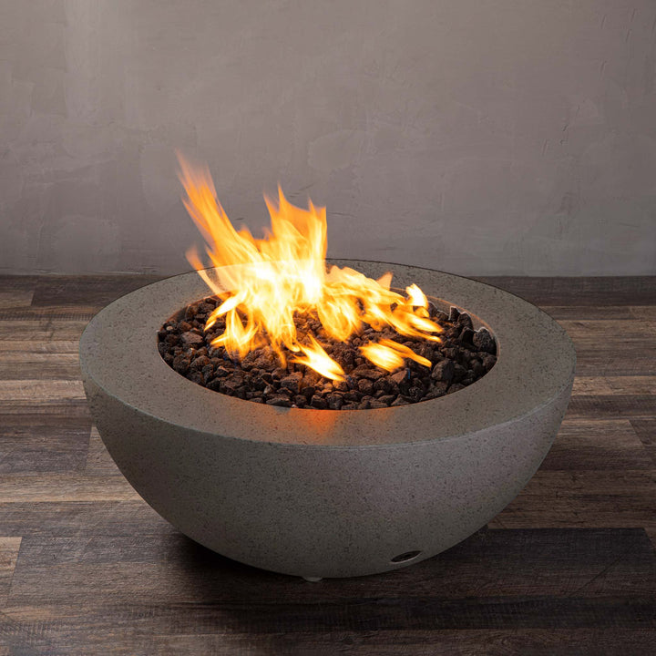 A side view of the Starfire Designs Gravity 36" Round Rustic Gravity Concrete (GFRC) Fire Pit - Propane Gas Hardline - Brown with flames on, featuring sleek modern concrete bowl design and durable construction, perfect for outdoor patio spaces. Natural gas or propane compatible, enhancing warmth and ambiance. Lava rocks included for added aesthetic.
