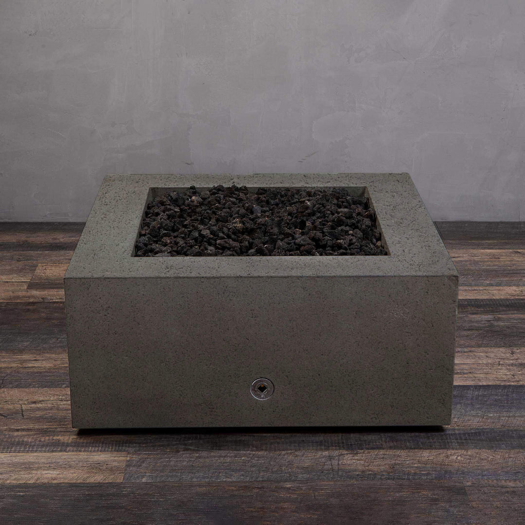 A side view of the Starfire Designs Gravity 36" Square Rustic Gravity Concrete (GFRC) Fire Pit - Propane Gas Hardline - Brown with flames on, featuring sleek modern concrete bowl design and durable construction, perfect for outdoor patio spaces. Natural gas or propane compatible, enhancing warmth and ambiance. Lava rocks included for added aesthetic.
