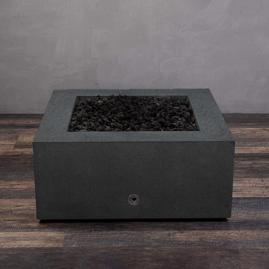 A side view of the Starfire Designs Gravity 36" Square Rustic Gravity Concrete (GFRC) Fire Pit - Propane Gas Hardline - Graphite with flames on, featuring sleek modern concrete bowl design and durable construction, perfect for outdoor patio spaces. Natural gas or propane compatible, enhancing warmth and ambiance. Lava rocks included for added aesthetic.
