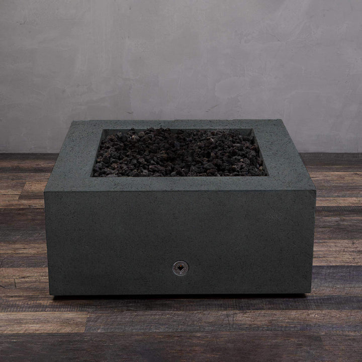 A side view of the Starfire Designs Gravity 36" Square Rustic Gravity Concrete (GFRC) Fire Pit - Propane Gas Hardline - Graphite with flames on, featuring sleek modern concrete bowl design and durable construction, perfect for outdoor patio spaces. Natural gas or propane compatible, enhancing warmth and ambiance. Lava rocks included for added aesthetic.
