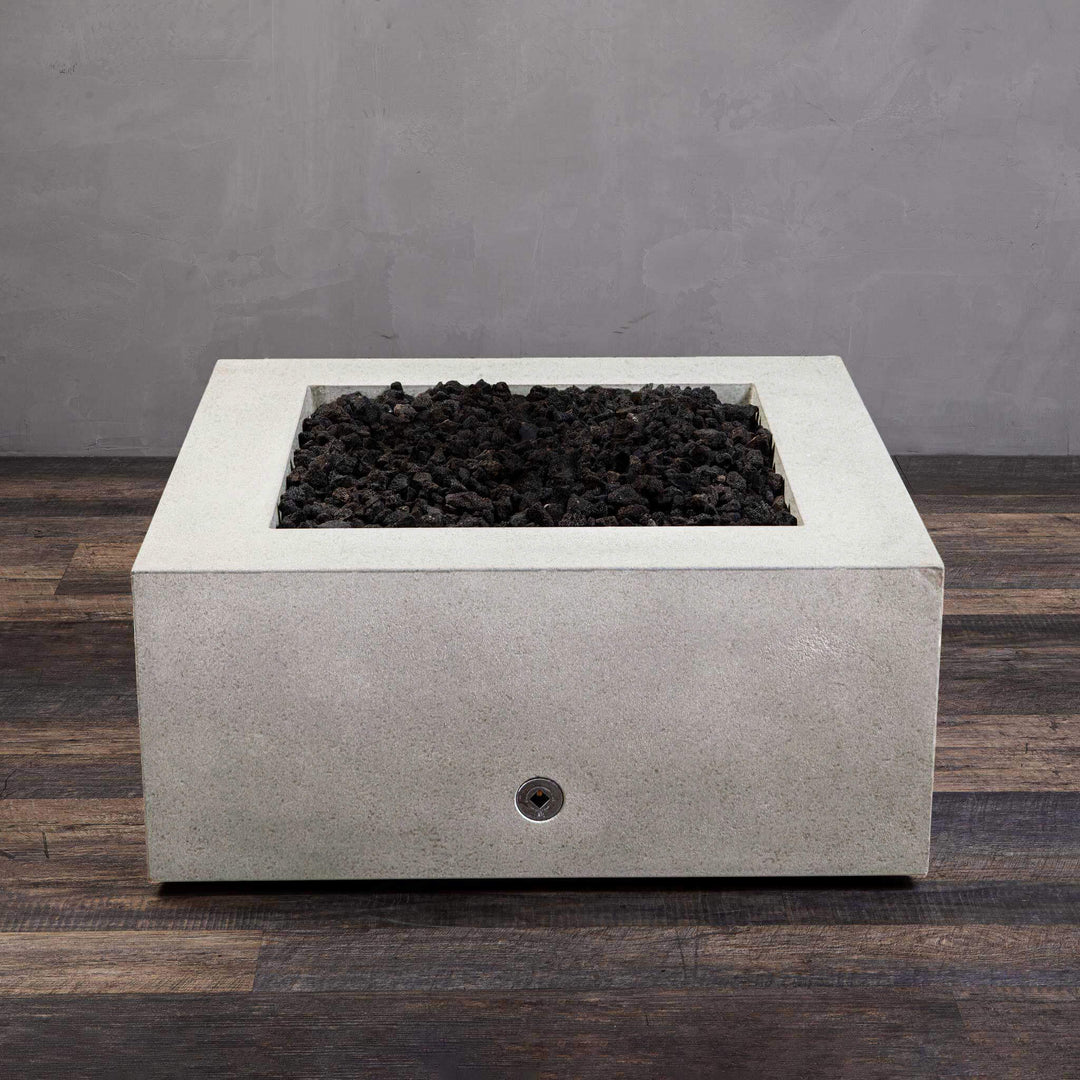 A side view of the Starfire Designs Gravity 36" Square Rustic Gravity Concrete (GFRC) Fire Pit - Propane Gas Hardline - White with flames on, featuring sleek modern concrete bowl design and durable construction, perfect for outdoor patio spaces. Natural gas or propane compatible, enhancing warmth and ambiance. Lava rocks included for added aesthetic.
