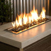 Sleek flames flicker over a bed of black 1/4” reflective fire glass by American Fire Products, creating a bold and modern contrast within a rectangular stainless steel fire pit—perfect for elevating any outdoor space.