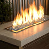 A contemporary fire table glowing with American Fire Products 1/4" Pacific Blue Reflective Fire Glass, where vivid ocean-blue glass pieces sparkle beneath tall, elegant flames—perfect for upscale outdoor spaces.