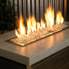 1/4" Platinum Reflective Fire Glass by American Fire Products glowing beneath a bold, elegant flame in a modern fire pit—its crystal-clear shards and mirrored finish create a dazzling sparkle, adding contemporary flair and radiant ambiance to any outdoor setting.