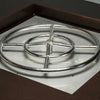 Round stainless steel gas burner with concentric rings and multiple ports installed in a fire pit, highlighting even flame distribution and durable construction for outdoor heating solutions