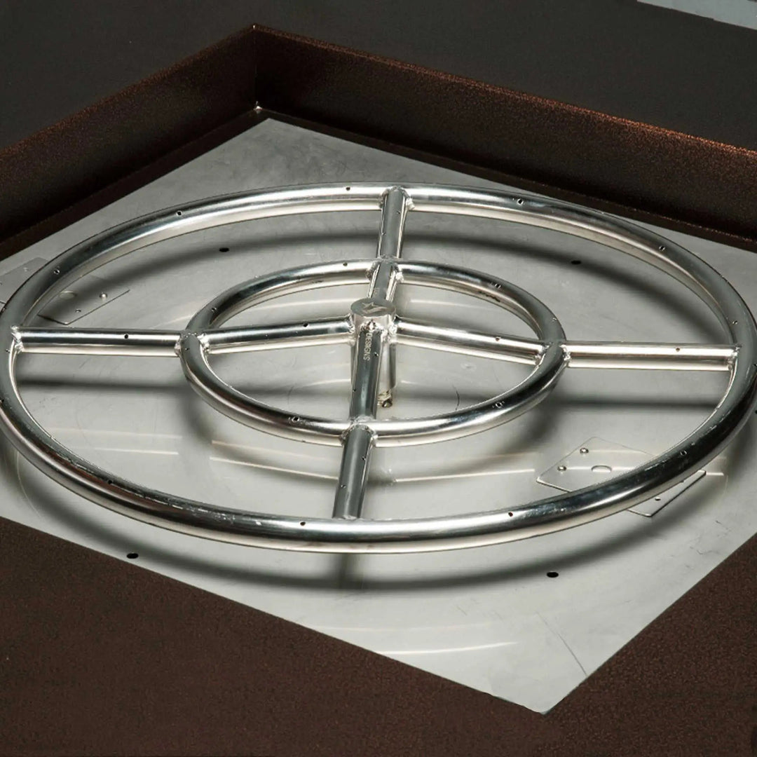 Round stainless steel gas burner with concentric rings and multiple ports installed in a fire pit, highlighting even flame distribution and durable construction for outdoor heating solutions