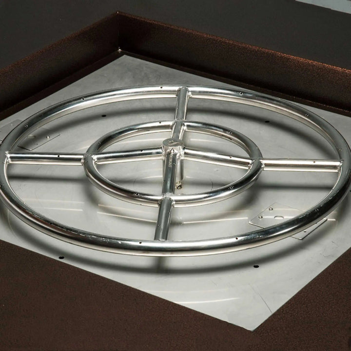 Round stainless steel gas burner with concentric rings and multiple ports installed in a fire pit, highlighting even flame distribution and durable construction for outdoor heating solutions