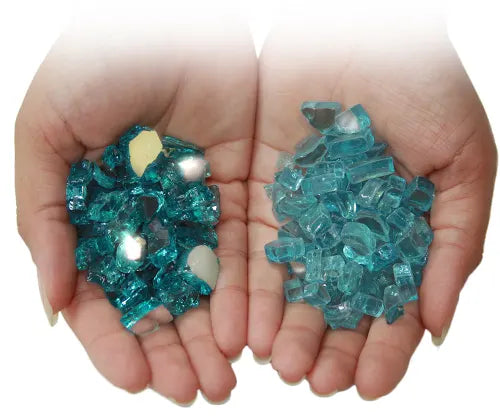 Close-up of two hands holding blue reflective fire glass, showcasing a mix of smooth and jagged pieces perfect for enhancing the aesthetic of fire pits and fireplaces.