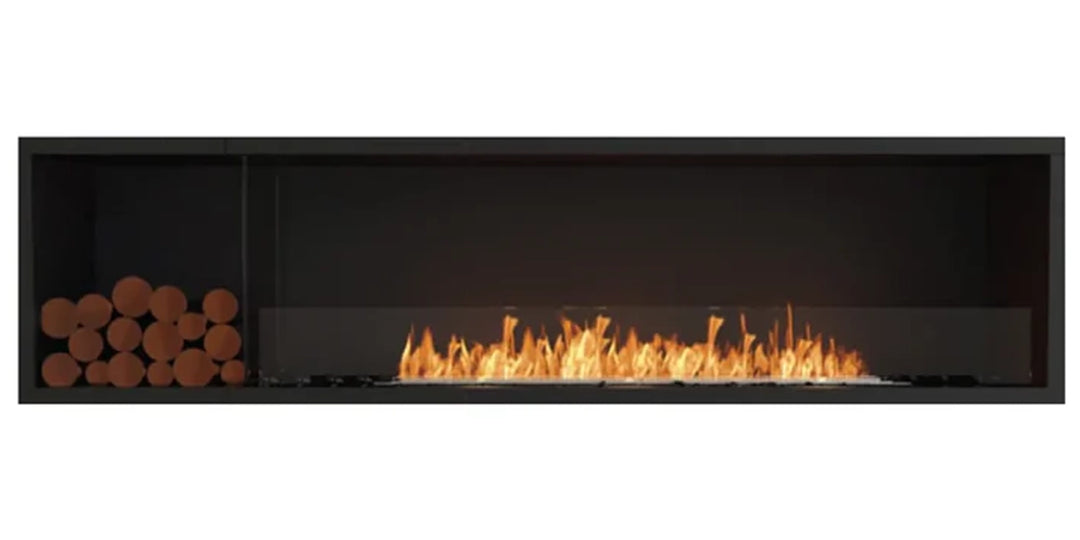 Contemporary linear fireplace with a black frame, wide central flame, and a stack of wooden logs on the left, combining modern design with a touch of rustic warmth.