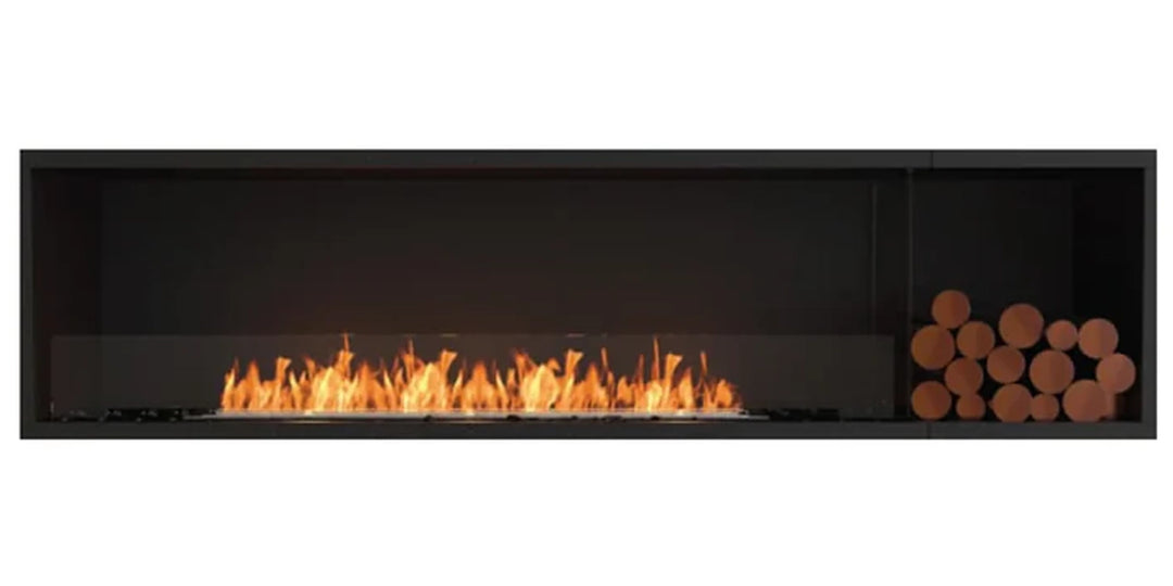 Modern linear fireplace with a sleek black frame, featuring a wide central flame and a stack of wooden logs on one side, combining contemporary design with rustic warmth