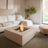 A modern indoor fire pit setup featuring the EcoSmart Fire Base 40, surrounded by plush white furniture in a minimalist living space. The fire pitâ€™s concrete fire pit table design blends seamlessly into the decor, providing warmth and elegance as a stylish fire table propane alternative.