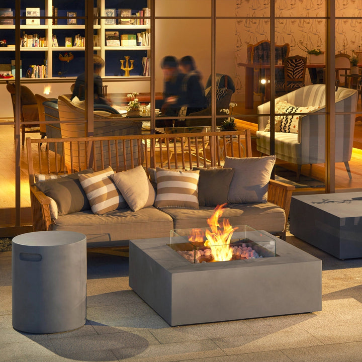 The EcoSmart Fire Base 40 fire pit set in an outdoor lounge with soft lighting and cozy seating, creating an inviting atmosphere. The fire pit table outdoor design enhances the space, offering both functionality and modern aesthetics for a gas fire bowl outdoor experience.