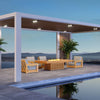 A teak-finished EcoSmart Fire Gin 90 Chat Height outdoor fire pit table is beautifully positioned on a poolside patio, surrounded by modern lounge chairs and tropical plants. The sleek, slatted wood design and warm gas flame create an inviting outdoor gathering space, ideal for backyard entertaining, commercial patio setups, or modern fire pit designs.