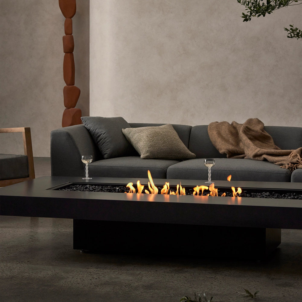 A close-up of the EcoSmart Fire Gin 90 Low fire table, showcasing its realistic flames dancing over black fire media. The sleek and modern design makes this indoor fire pit a perfect fire table for contemporary living rooms. Its long burner and minimalistic styling elevate any space with a sophisticated and warm ambiance.
