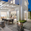 A stylish EcoSmart Fire Mix 850 bone fire pit with a stainless steel burner, placed on a modern outdoor patio. The sleek, bowl-shaped fire pit is filled with black fire glass, producing a warm, inviting flame. This luxury fire pit is ideal for outdoor gatherings, adding a contemporary ambiance to high-end patios and backyards.